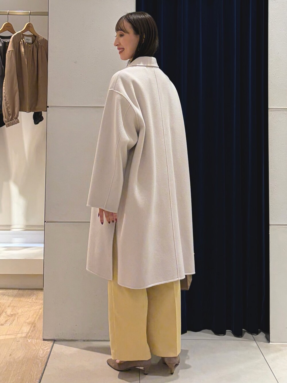 ベージュ系のステンカラーコート、ホワイト系のTシャツ/カットソー、イエロー系のその他パンツを着用したレディースの秋コーディネートの8枚目の写真