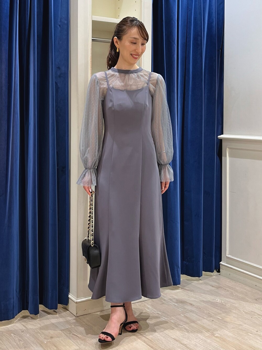 グレー系のワンピース、ブラック系のショルダーバッグを着用したレディースの夏コーディネートの7枚目の写真