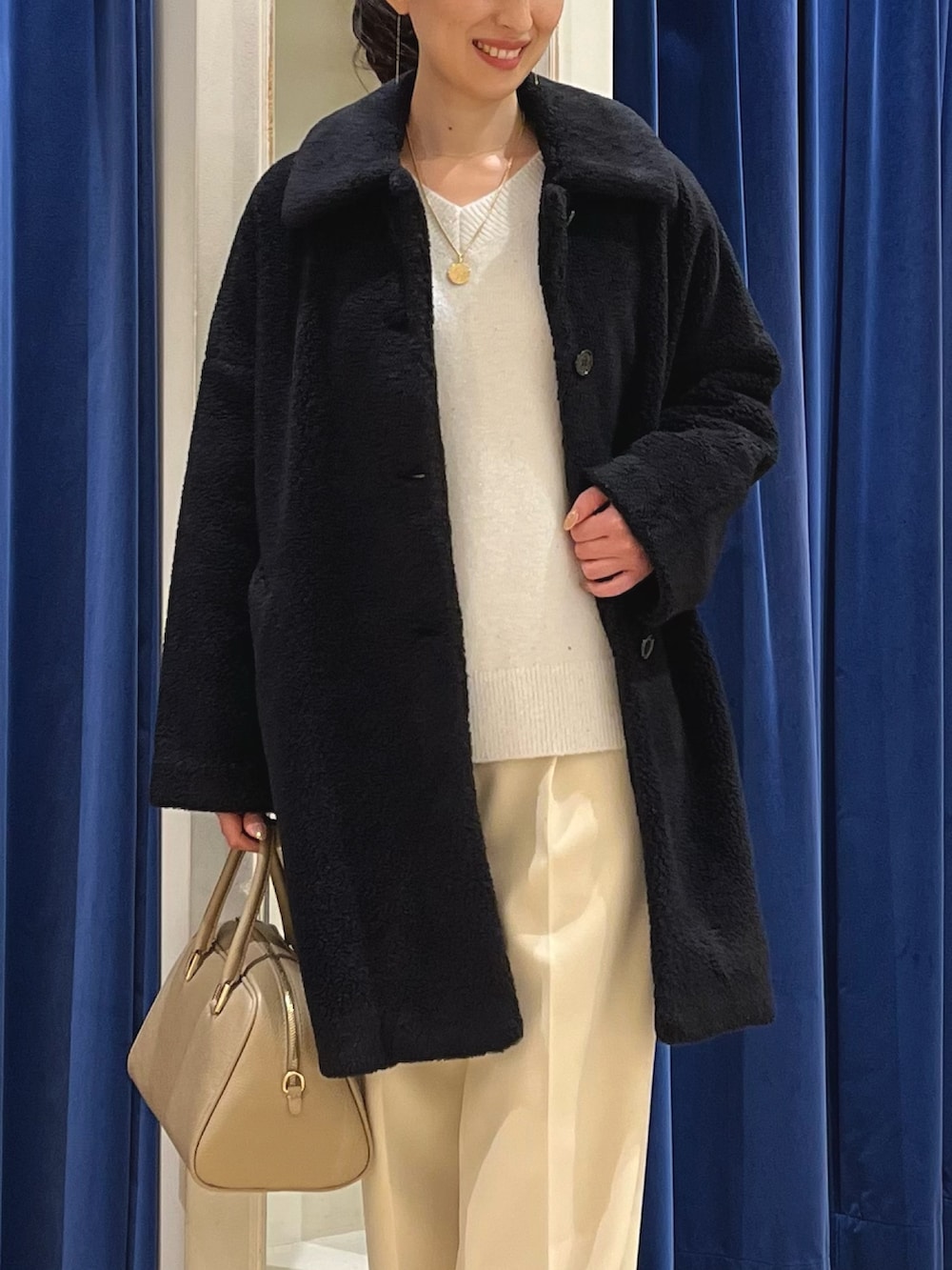 ブラック系のダッフルコート、ホワイト系のニット/セーター、イエロー系のその他パンツを着用したレディースの冬コーディネートの3枚目の写真