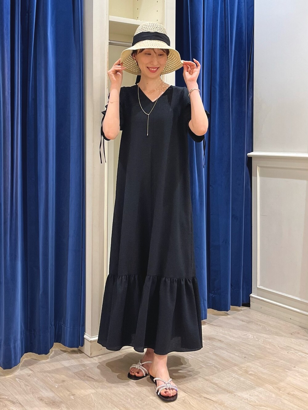 シルバー系のサンダル、ブラック系のワンピース、ベージュ系のハットを着用したレディースの春コーディネートの4枚目の写真