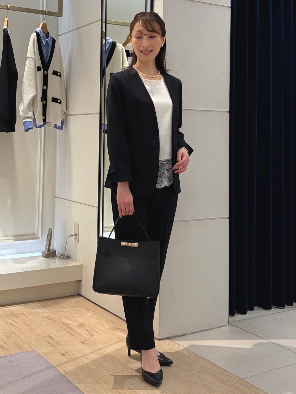 ホワイト系のシャツ/ブラウス、ブルー系のノーカラージャケット、ブラック系のショルダーバッグを着用したレディースの冬コーディネートの6枚目の写真