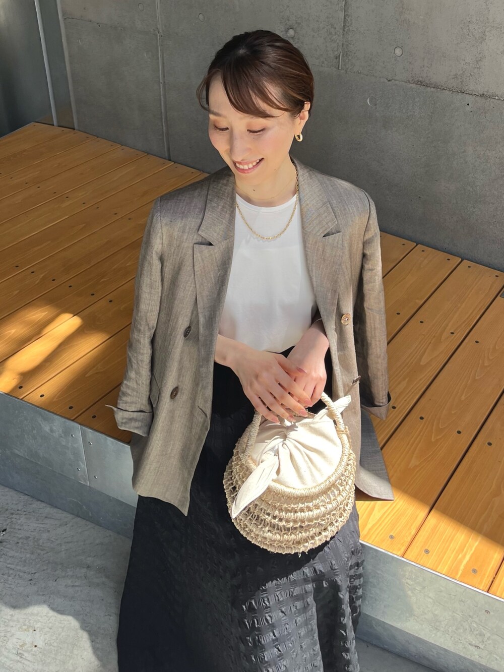 ホワイト系のTシャツ/カットソー、ブラック系のスカート、ブラウン系のテーラードジャケットを着用したレディースの夏コーディネートの10枚目の写真