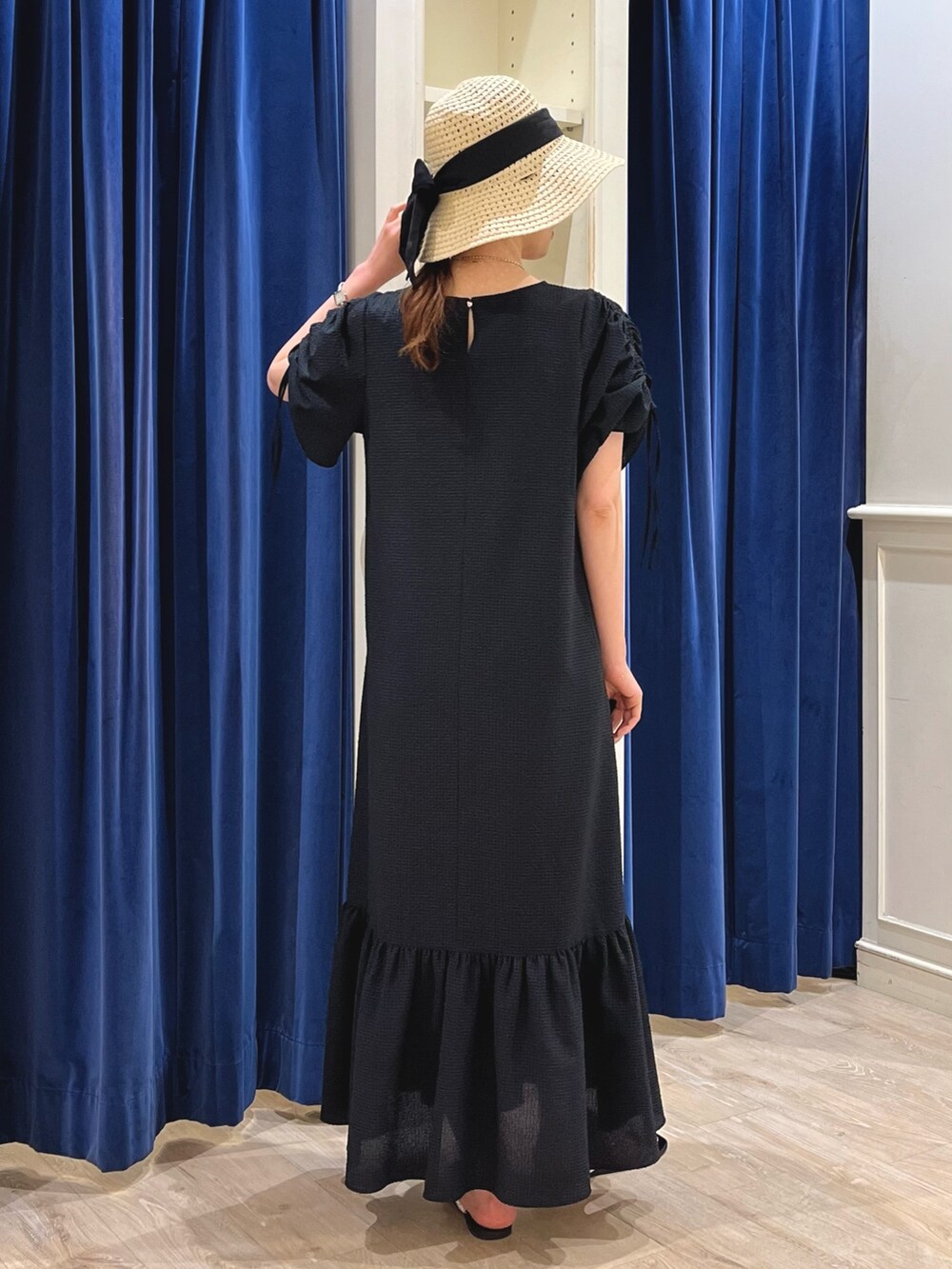 シルバー系のサンダル、ブラック系のワンピース、ベージュ系のハットを着用したレディースの春コーディネートの6枚目の写真