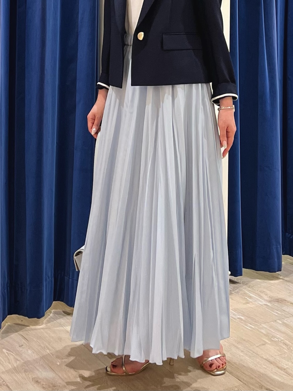 ブルー系のテーラードジャケット、ホワイト系のタンクトップ、ブルー系のスカートを着用したレディースの夏コーディネートの4枚目の写真