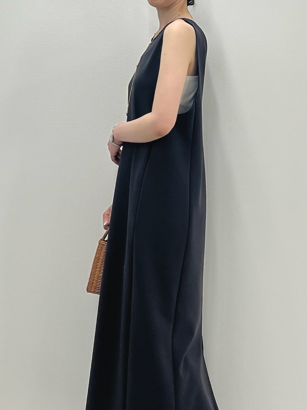 グレー系のワンピース、イエロー系のかごバッグ、シルバー系のサンダルを着用したレディースの春コーディネートの4枚目の写真