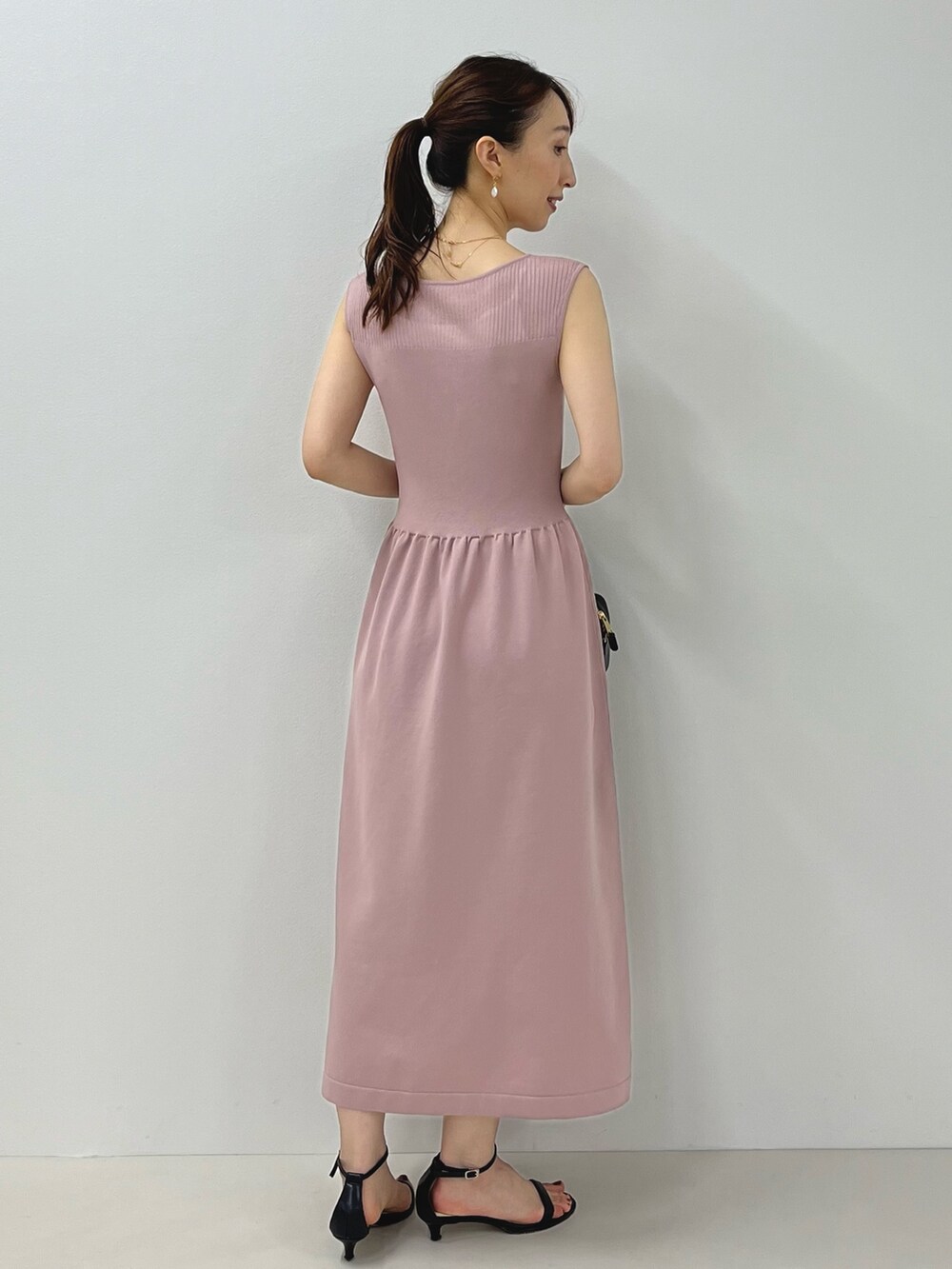 ピンク系のワンピース、ブラック系のサンダル、ゴールド系のピアス(両耳用)を着用したレディースの夏コーディネートの10枚目の写真