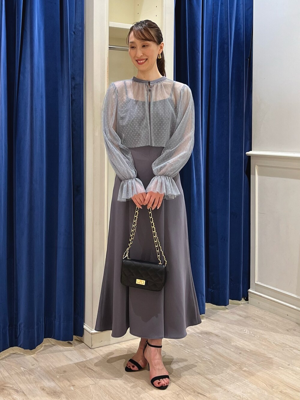 グレー系のワンピース、ブラック系のショルダーバッグを着用したレディースの夏コーディネートの5枚目の写真