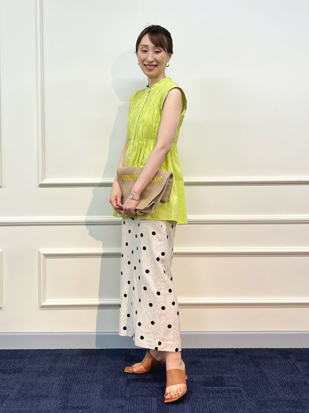 グリーン系のシャツ/ブラウス、イエロー系のトートバッグ、ベージュ系のスカートを着用したレディースの夏コーディネートの2枚目の写真