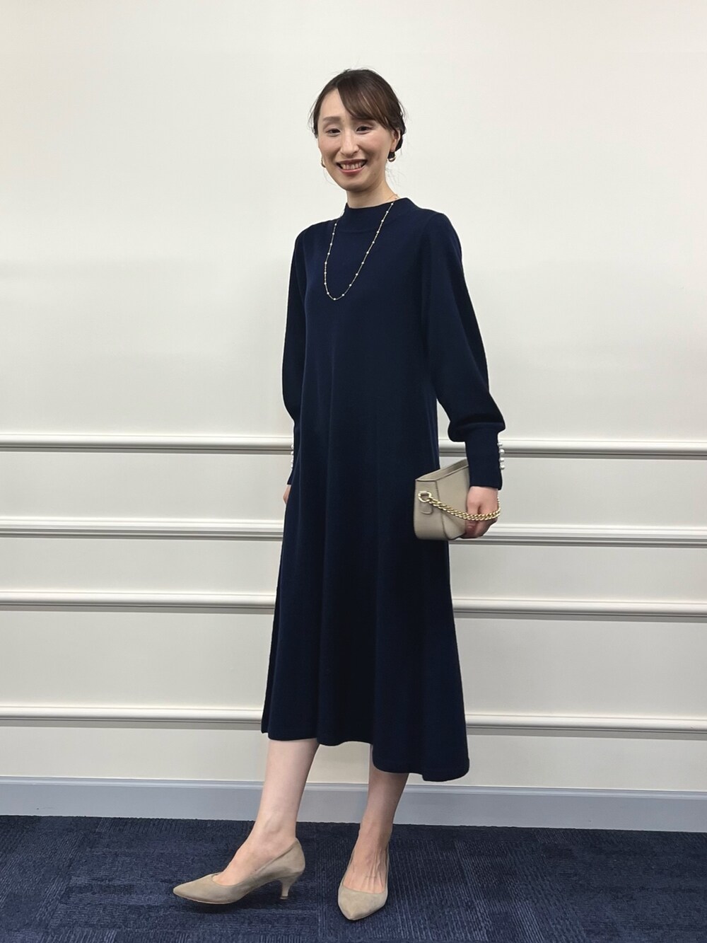 ベージュ系のショルダーバッグ、ブルー系のワンピース、ゴールド系のネックレスを着用したレディースの冬コーディネートの6枚目の写真