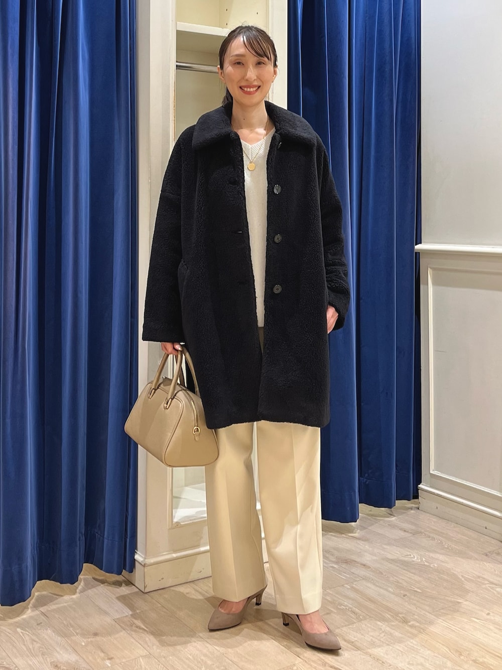 ブラック系のダッフルコート、ホワイト系のニット/セーター、イエロー系のその他パンツを着用したレディースの冬コーディネートの2枚目の写真