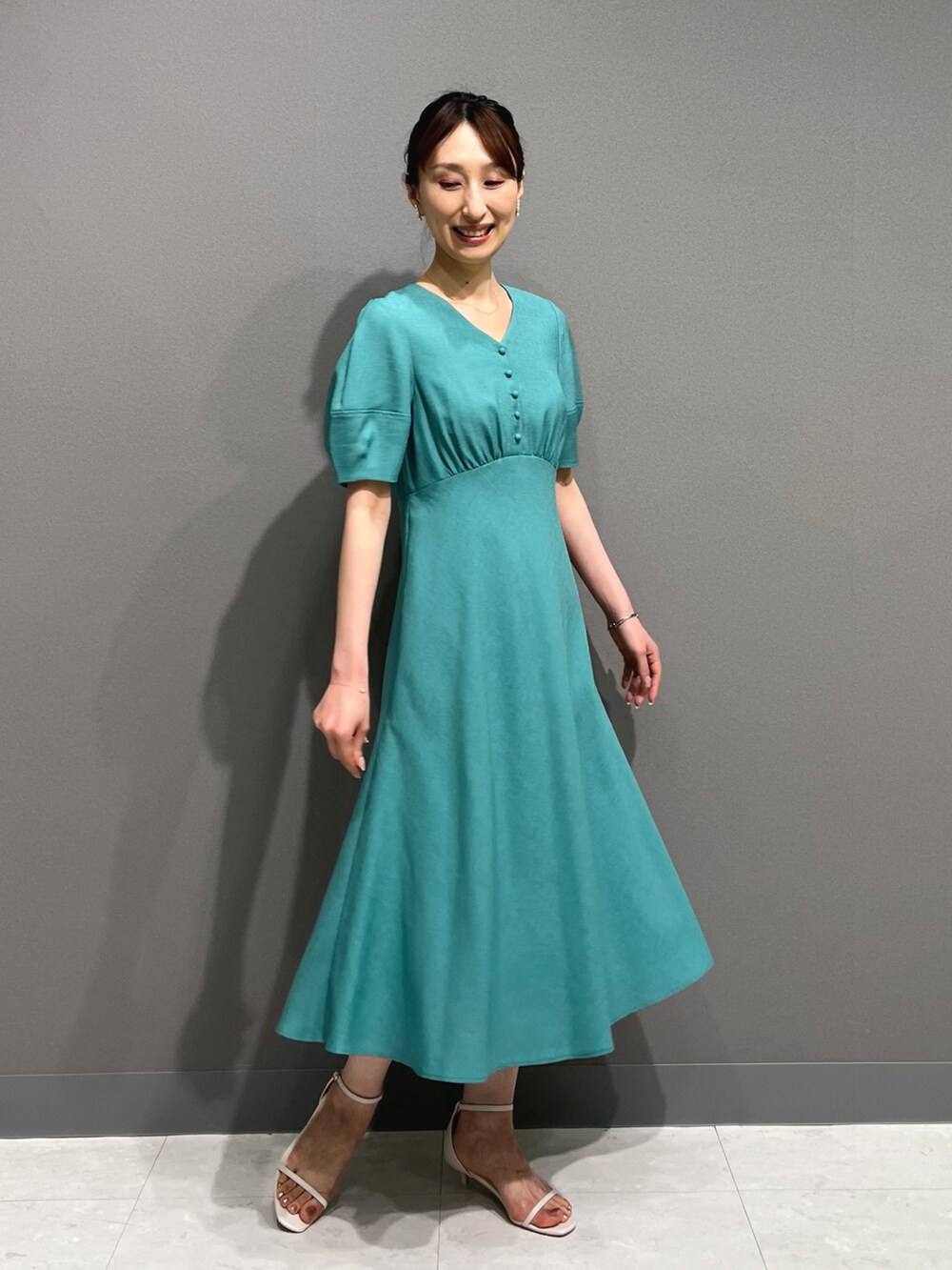 ブルー系のワンピース、ホワイト系のサンダル、ホワイト系のイヤリングを着用したレディースの春コーディネートの4枚目の写真