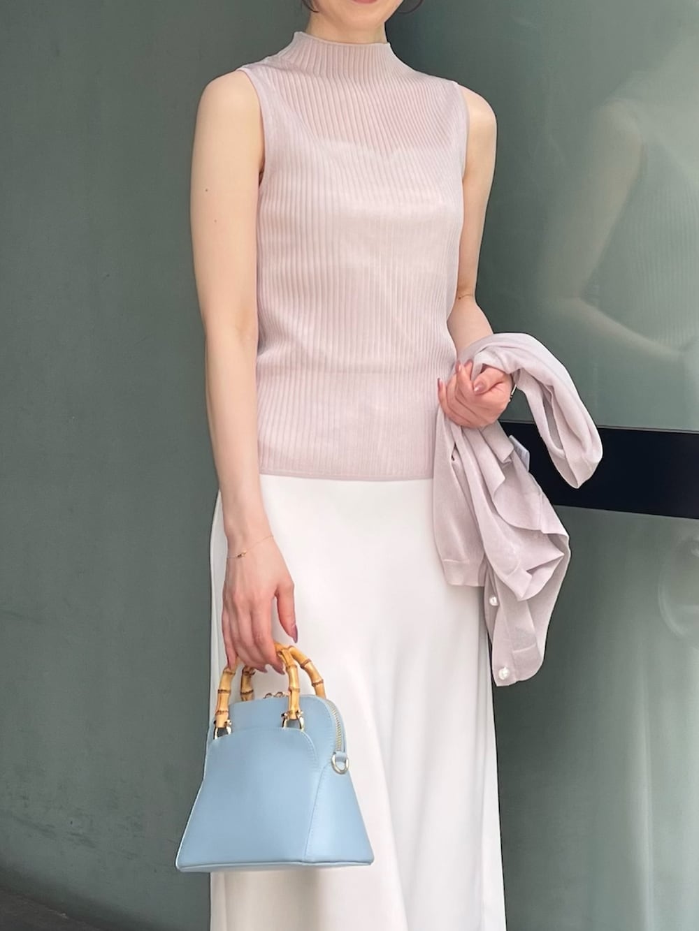 ホワイト系のキャミソール、ベージュ系のニット/セーター、ベージュ系のカーディガン/ボレロを着用したレディースの夏コーディネートの4枚目の写真