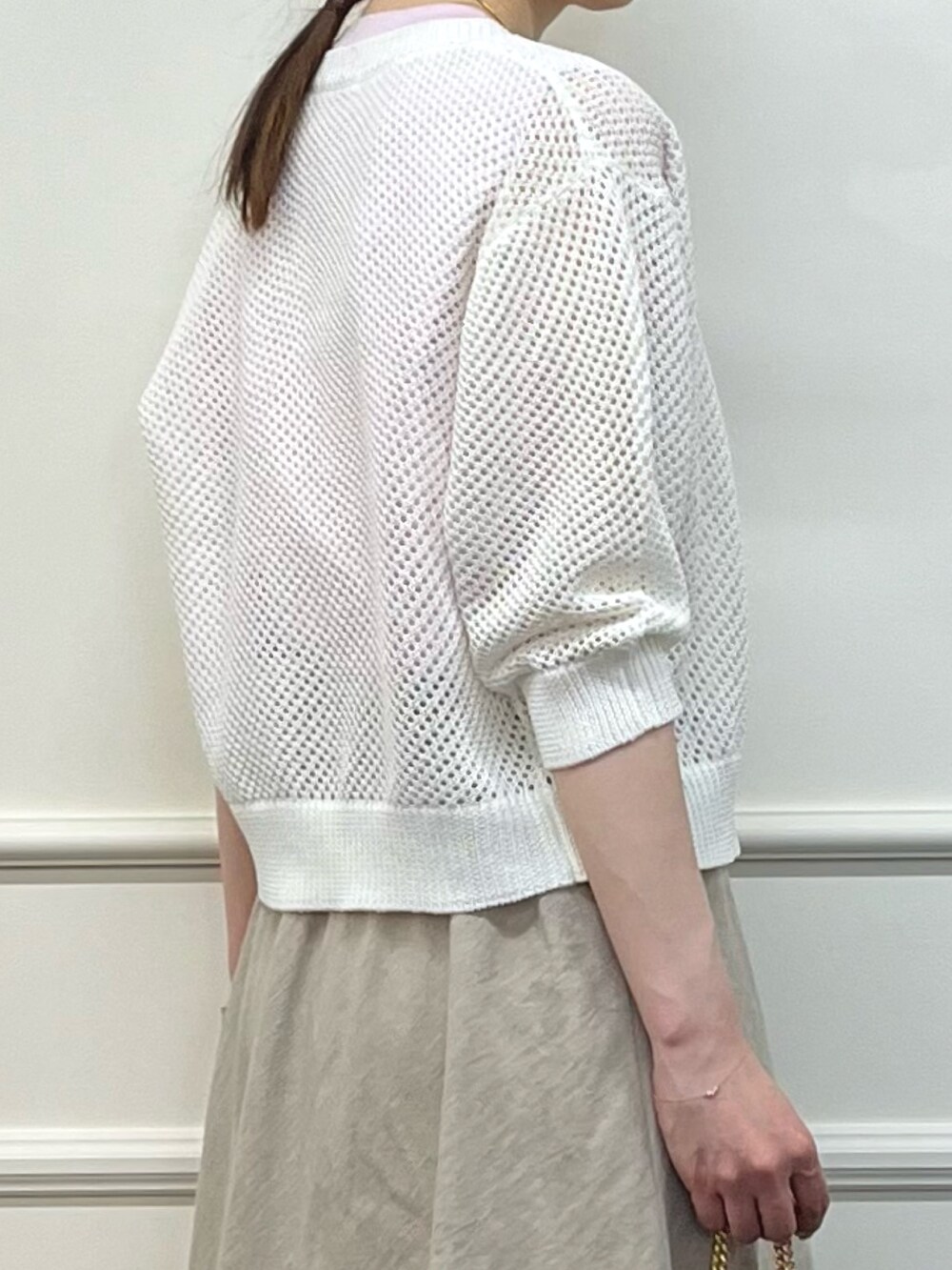 ホワイト系のカーディガン/ボレロ、ピンク系のTシャツ/カットソー、ベージュ系のスカートを着用したレディースの夏コーディネートの6枚目の写真