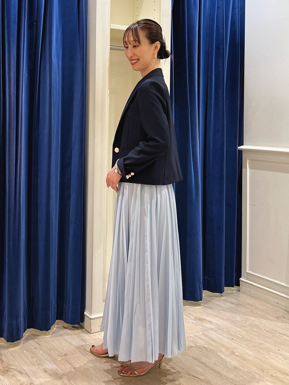 ブルー系のテーラードジャケット、ホワイト系のタンクトップ、ブルー系のスカートを着用したレディースの夏コーディネートの8枚目の写真