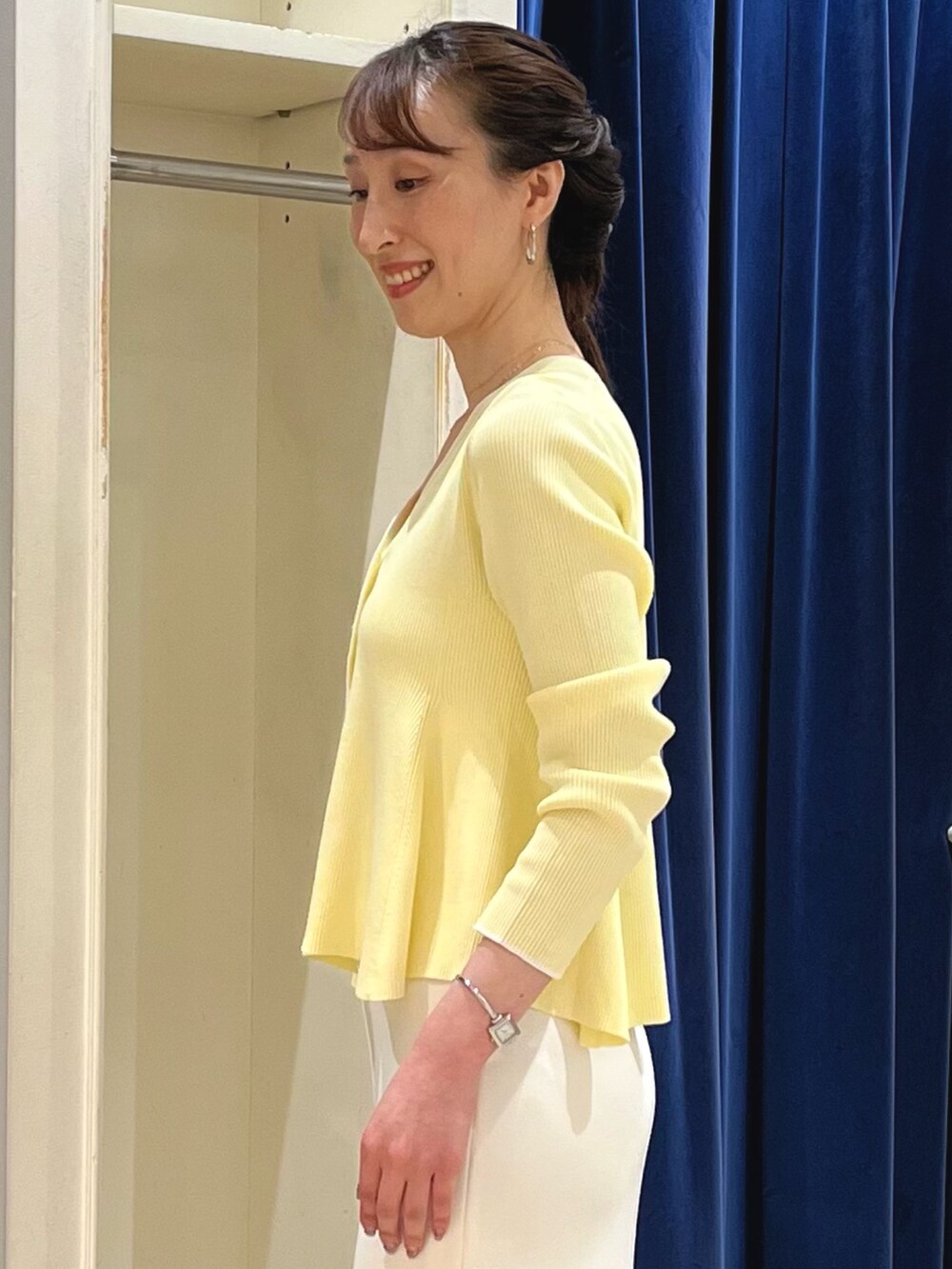 ベージュ系のカーディガン/ボレロ、ホワイト系のスカート、ベージュ系のボストンバッグを着用したレディースの春コーディネートの5枚目の写真