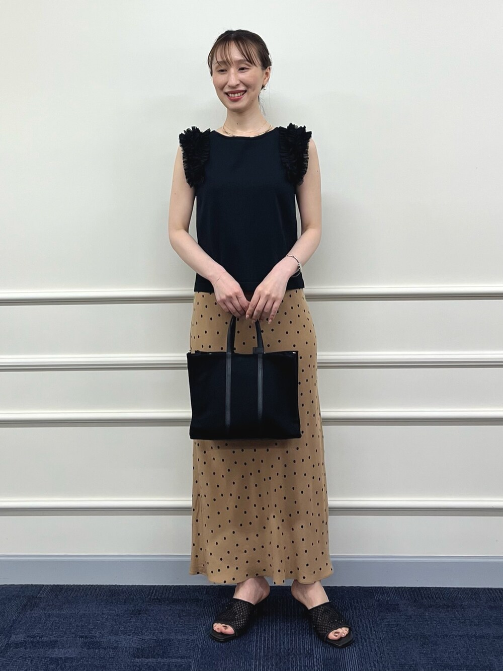 ブラック系のニット/セーター、ブラウン系のスカート、ブラック系のトートバッグを着用したレディースの夏コーディネートの8枚目の写真