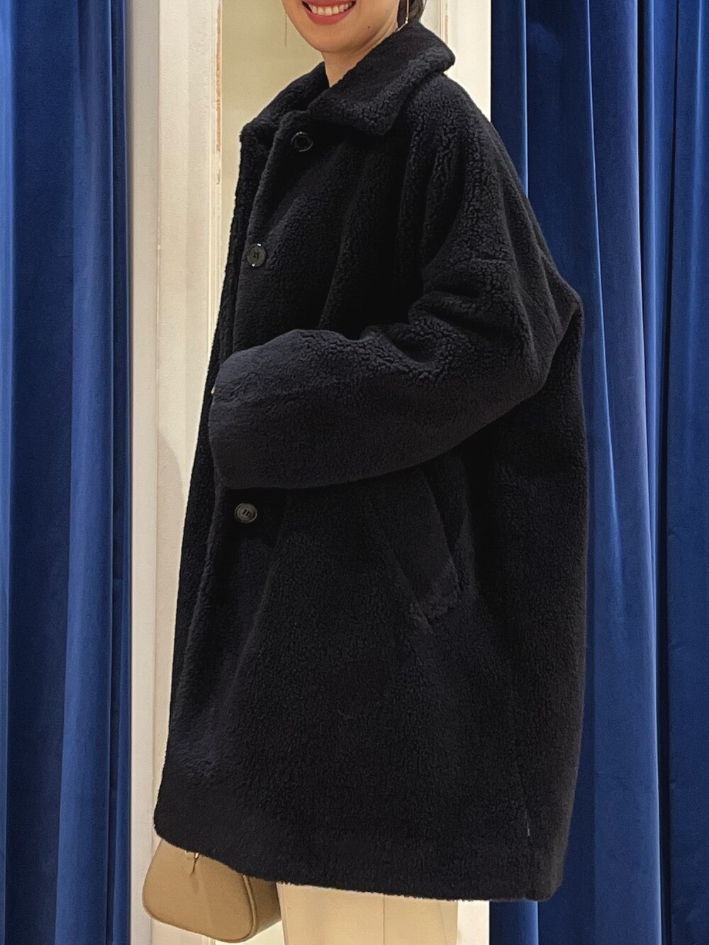 ブラック系のダッフルコート、ホワイト系のニット/セーター、イエロー系のその他パンツを着用したレディースの冬コーディネートの5枚目の写真