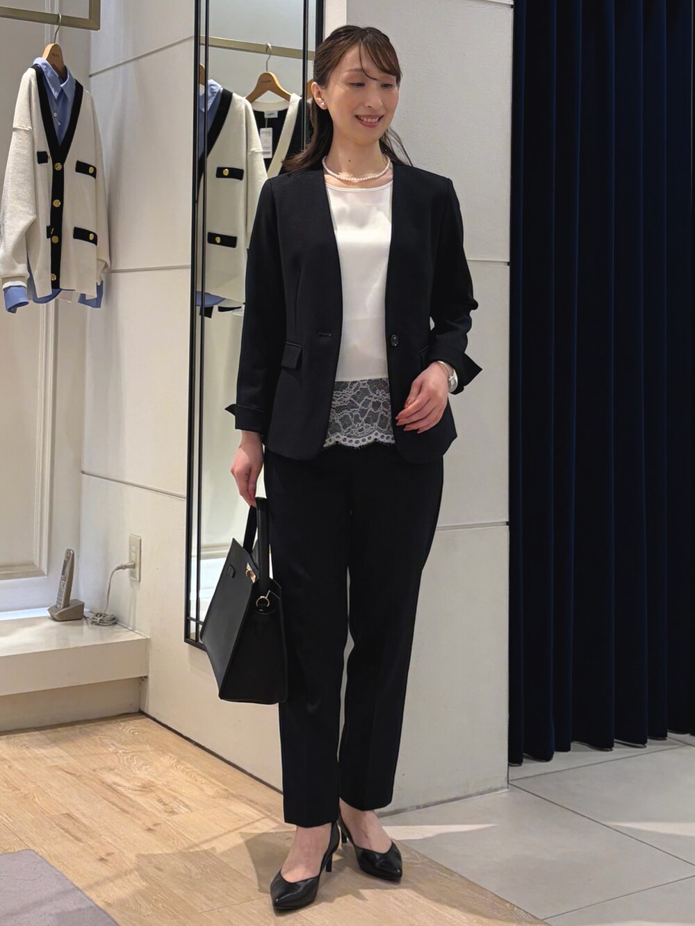 ホワイト系のシャツ/ブラウス、ブルー系のノーカラージャケット、ブラック系のショルダーバッグを着用したレディースの冬コーディネートの8枚目の写真