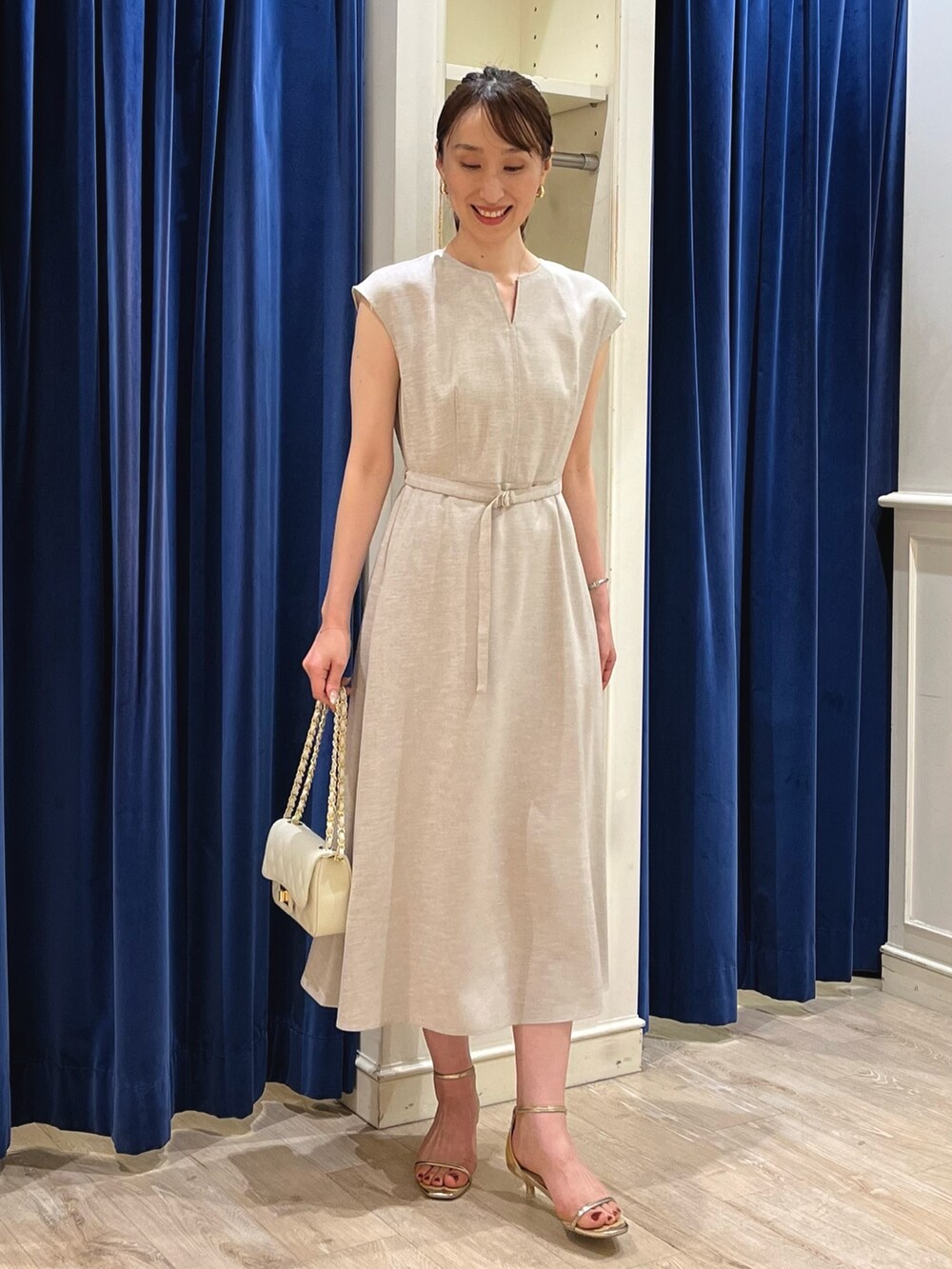 ベージュ系のワンピース、ホワイト系のショルダーバッグ、ゴールド系のサンダルを着用したレディースの夏コーディネートの8枚目の写真