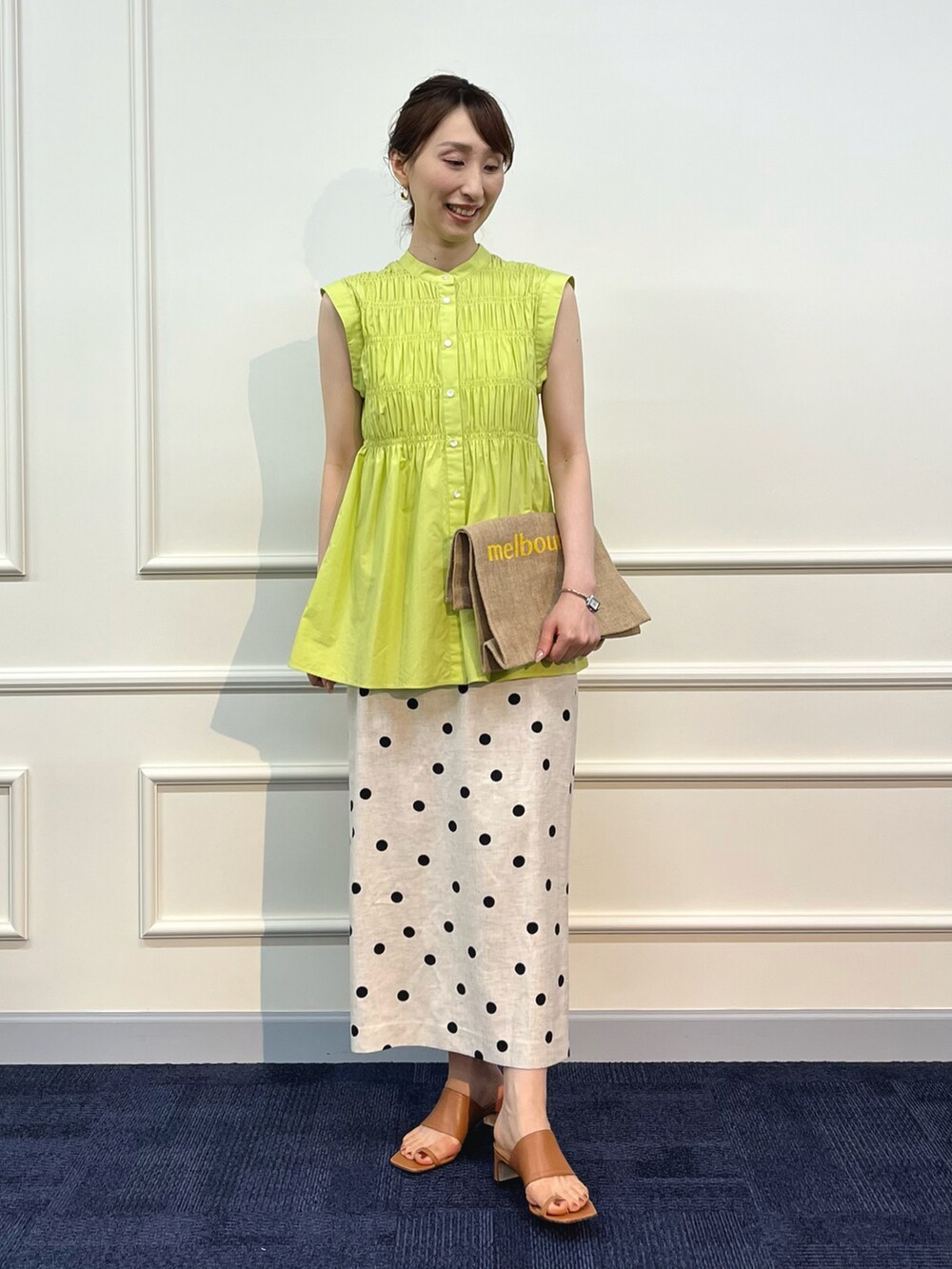 グリーン系のシャツ/ブラウス、イエロー系のトートバッグ、ベージュ系のスカートを着用したレディースの夏コーディネートの3枚目の写真
