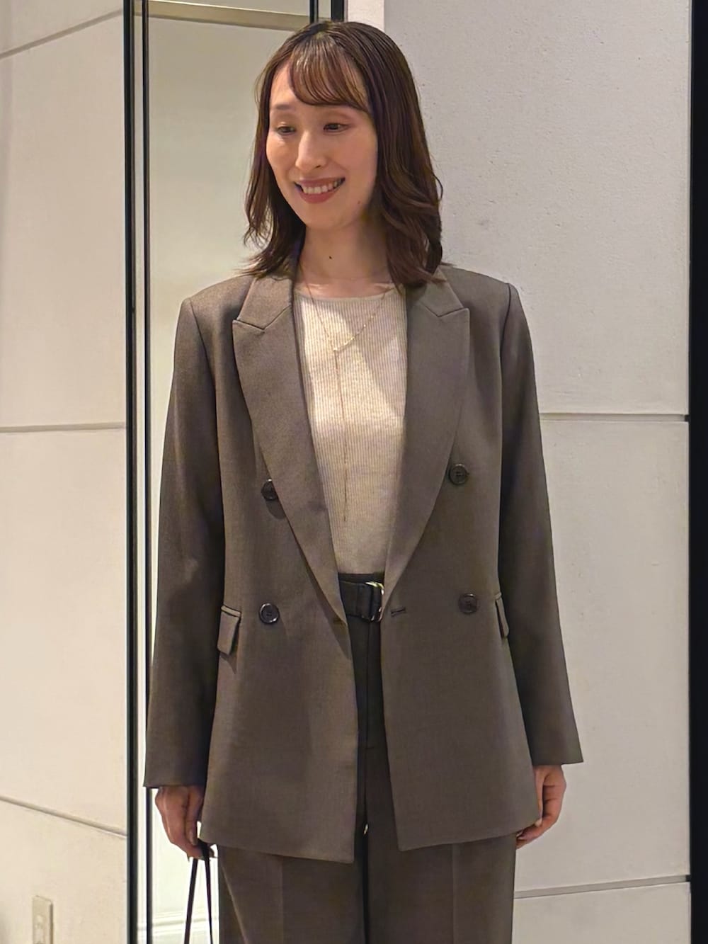 ベージュ系のニット/セーター、ブラウン系のテーラードジャケット、ブラウン系のその他パンツを着用したレディースの秋コーディネートの4枚目の写真