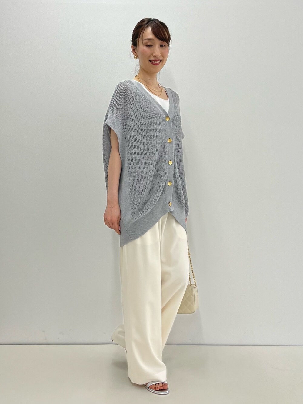 グレー系のベスト、ホワイト系のタンクトップ、ホワイト系のその他パンツを着用したレディースの春コーディネートの5枚目の写真