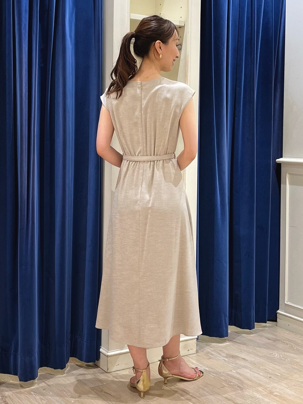 ベージュ系のワンピース、ホワイト系のショルダーバッグ、ゴールド系のサンダルを着用したレディースの夏コーディネートの10枚目の写真