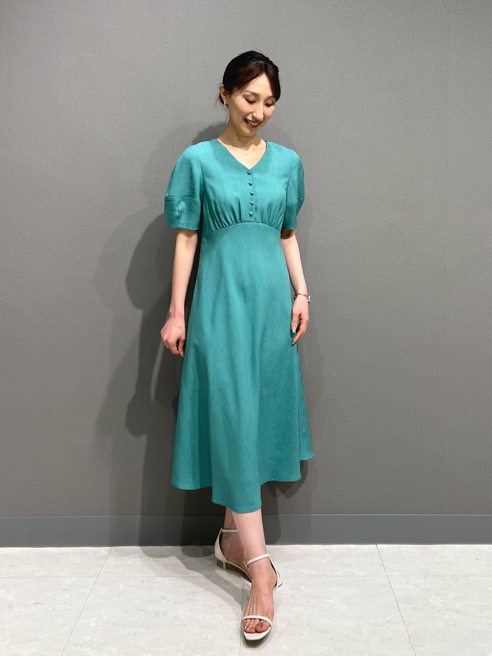 ブルー系のワンピース、ホワイト系のサンダル、ホワイト系のイヤリングを着用したレディースの春コーディネートの2枚目の写真