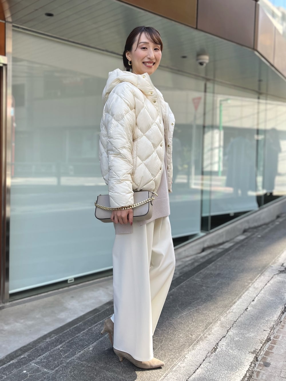 ホワイト系のダウンジャケット/コート、ベージュ系のニット/セーター、ベージュ系のショルダーバッグを着用したレディースの秋コーディネートの4枚目の写真
