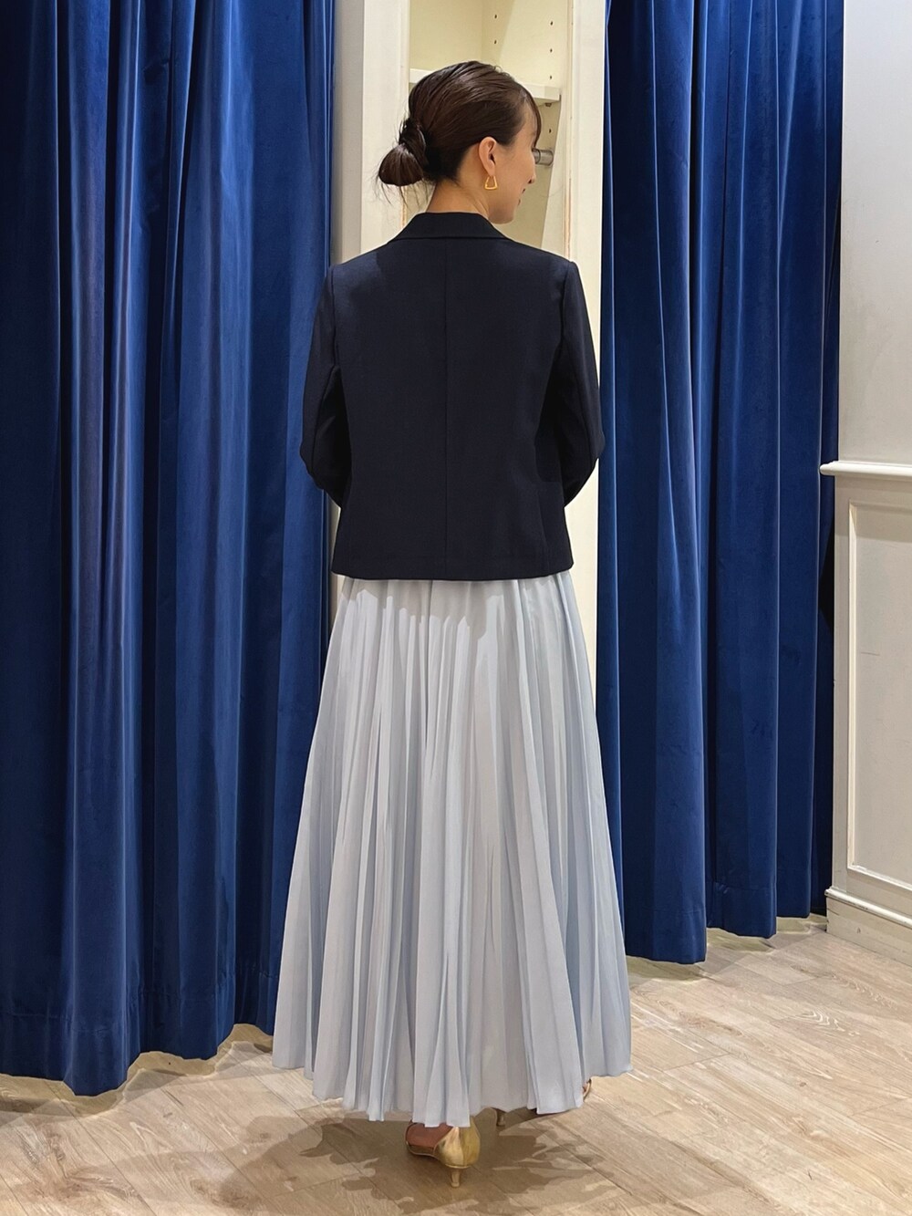 ブルー系のテーラードジャケット、ホワイト系のタンクトップ、ブルー系のスカートを着用したレディースの夏コーディネートの9枚目の写真