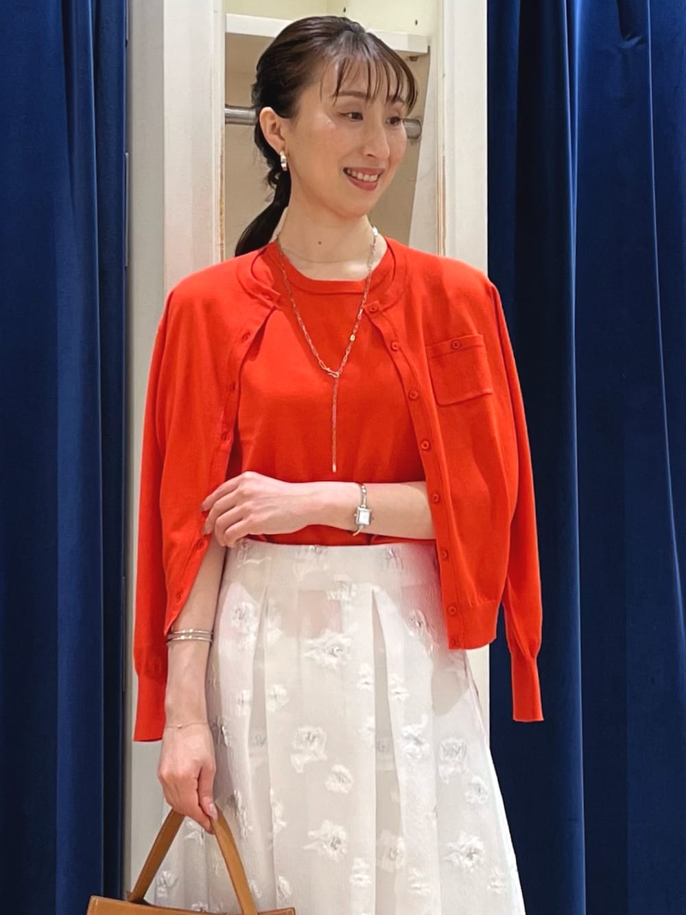 「デートコーデ、夏コーデ、ノースリーブ、お出かけコーデ、大人可愛い、カラーコーデ、大人かわいい、オレンジ、オレンジニット、アンサンブル、カーディガン、フラワープリント、フレアスカート、スカート、ノーリーズ」|「grace grace の【grace grace/グラスグラス】ニュアンスG型イヤリング(イヤリング、シルバー系)」を使った、nol ikeoさん(骨格ウェーブ・レディース・160cm)の夏コーディネートの3枚目の写真