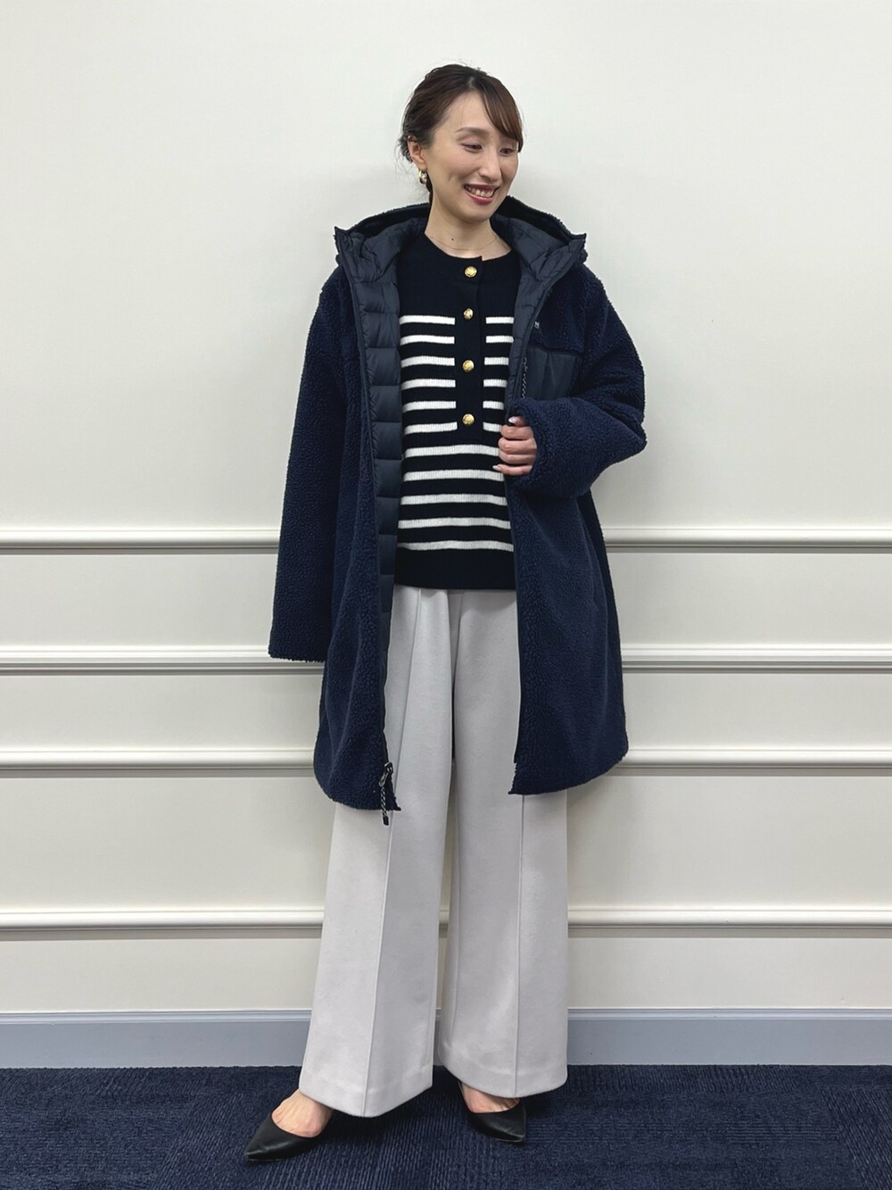 ブルー系のダウンジャケット/コート、ブラック系のニット/セーター、ベージュ系のその他パンツを着用したレディースの秋コーディネートの7枚目の写真