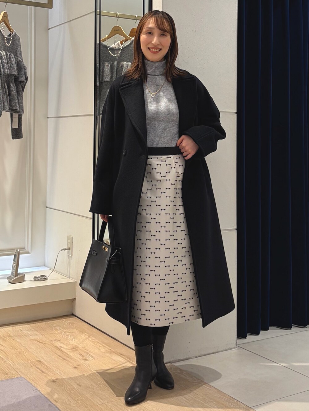 グレー系のその他トップス、ブラック系のその他アウター、ベージュ系のスカートを着用したレディースの冬コーディネートの6枚目の写真