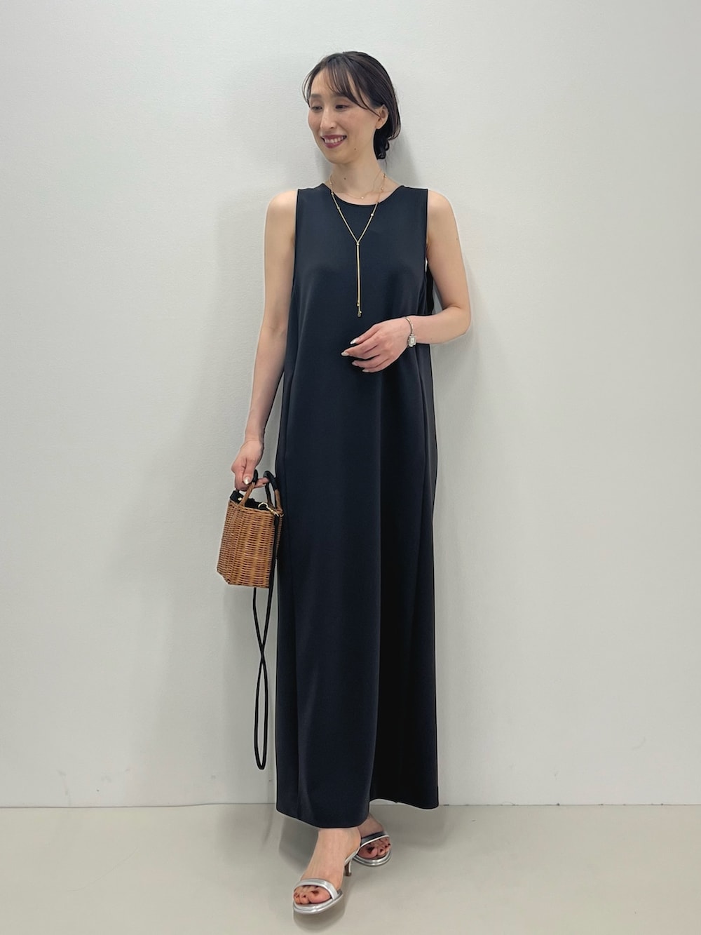 グレー系のワンピース、イエロー系のかごバッグ、シルバー系のサンダルを着用したレディースの春コーディネートの8枚目の写真