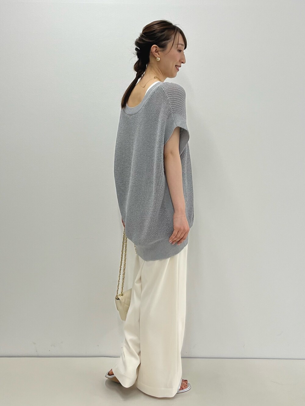 グレー系のベスト、ホワイト系のタンクトップ、ホワイト系のその他パンツを着用したレディースの春コーディネートの9枚目の写真