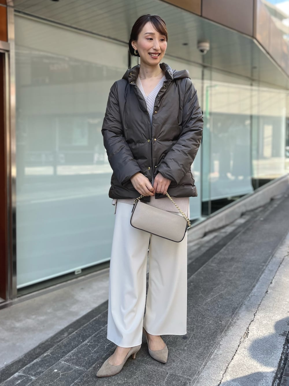 グリーン系のダウンジャケット/コート、ベージュ系のニット/セーター、ホワイト系のその他パンツを着用したレディースの秋コーディネートの3枚目の写真