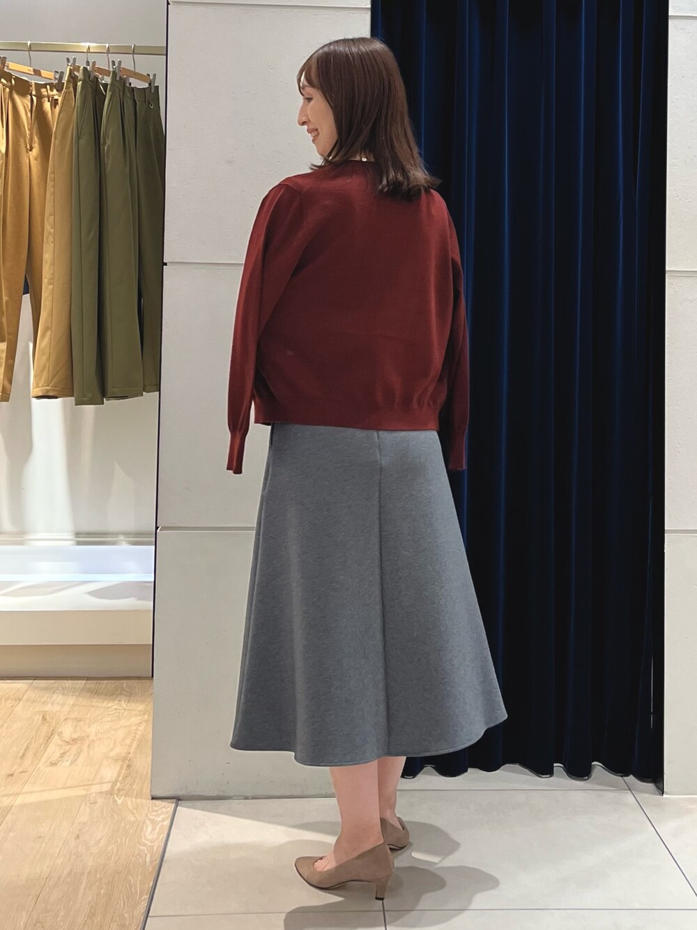 レッド系のニット/セーター、レッド系のカーディガン/ボレロ、グレー系のスカートを着用したレディースの秋コーディネートの10枚目の写真