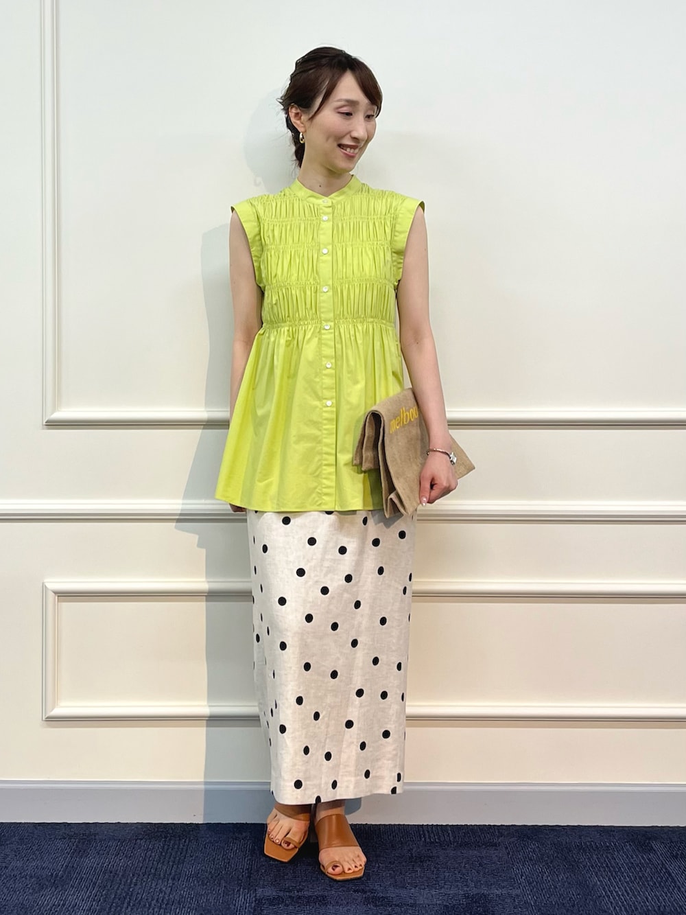 グリーン系のシャツ/ブラウス、イエロー系のトートバッグ、ベージュ系のスカートを着用したレディースの夏コーディネートの4枚目の写真