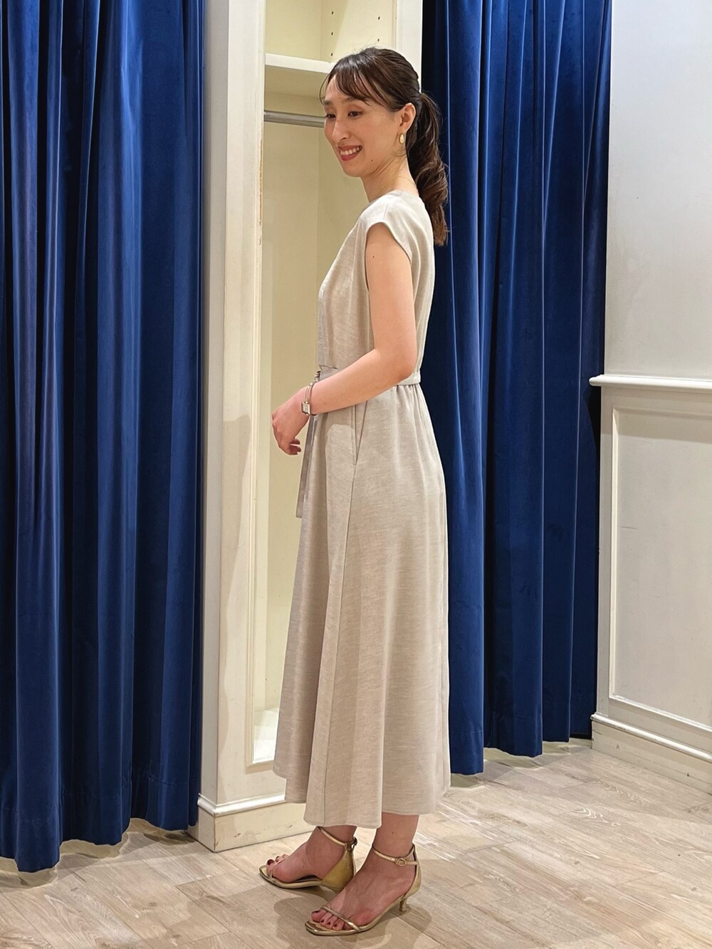 ベージュ系のワンピース、ホワイト系のショルダーバッグ、ゴールド系のサンダルを着用したレディースの夏コーディネートの4枚目の写真