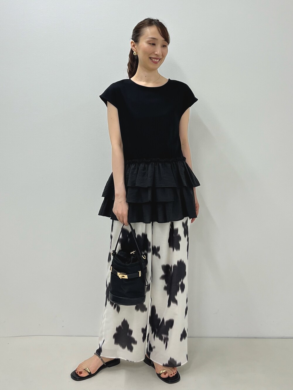 ブラック系のサンダル、ブラック系のTシャツ/カットソー、ホワイト系のその他パンツを着用したレディースの夏コーディネートの6枚目の写真