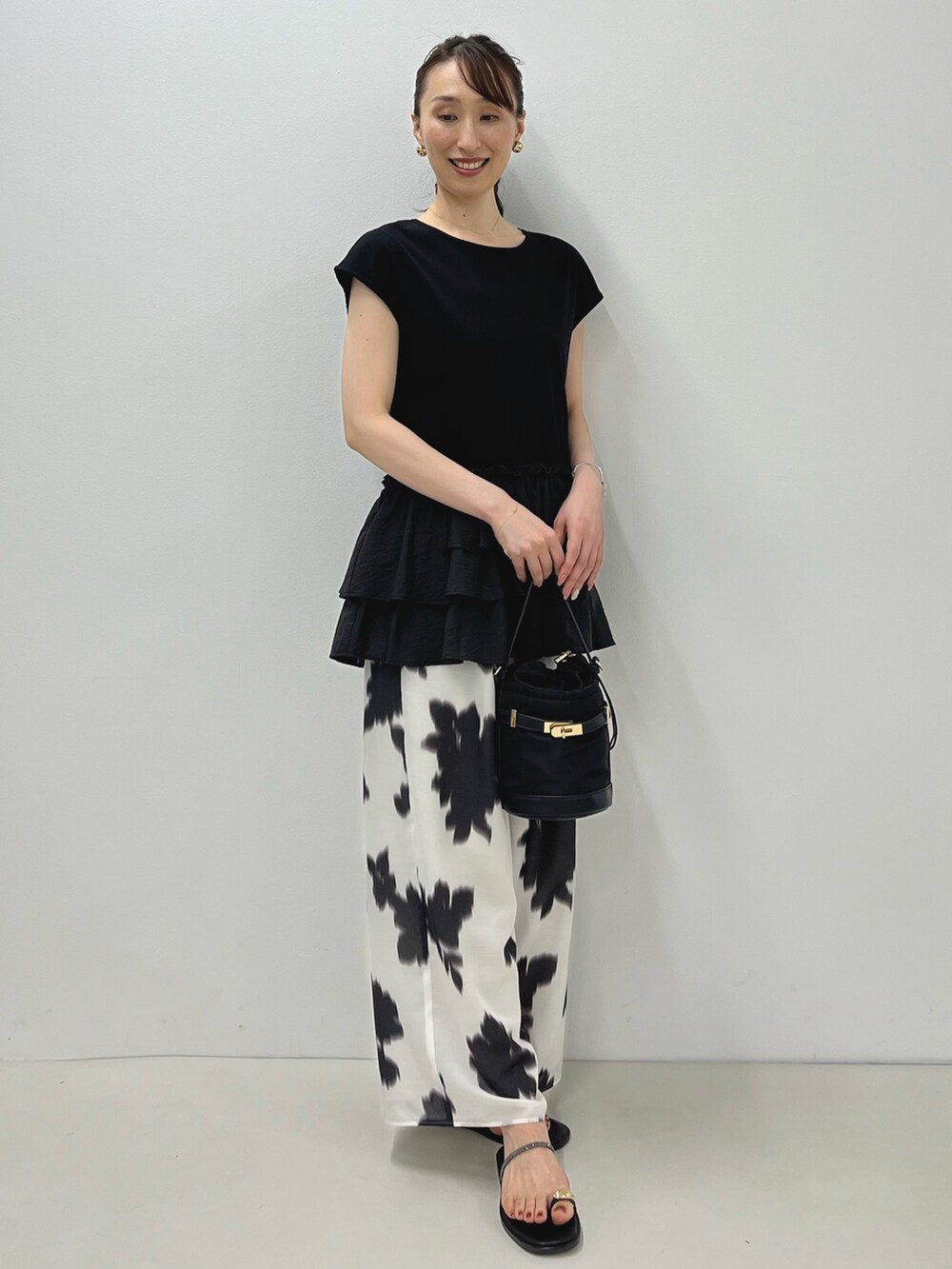 ブラック系のサンダル、ブラック系のTシャツ/カットソー、ホワイト系のその他パンツを着用したレディースの夏コーディネートの7枚目の写真