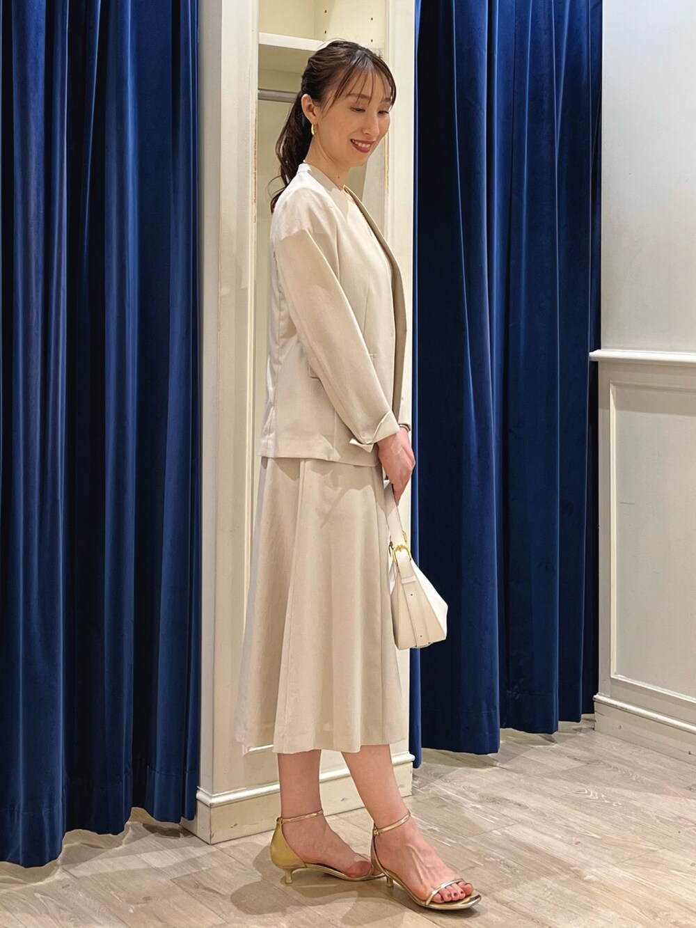 ベージュ系のノーカラージャケット、ホワイト系のショルダーバッグ、ゴールド系のサンダルを着用したレディースの夏コーディネートの8枚目の写真