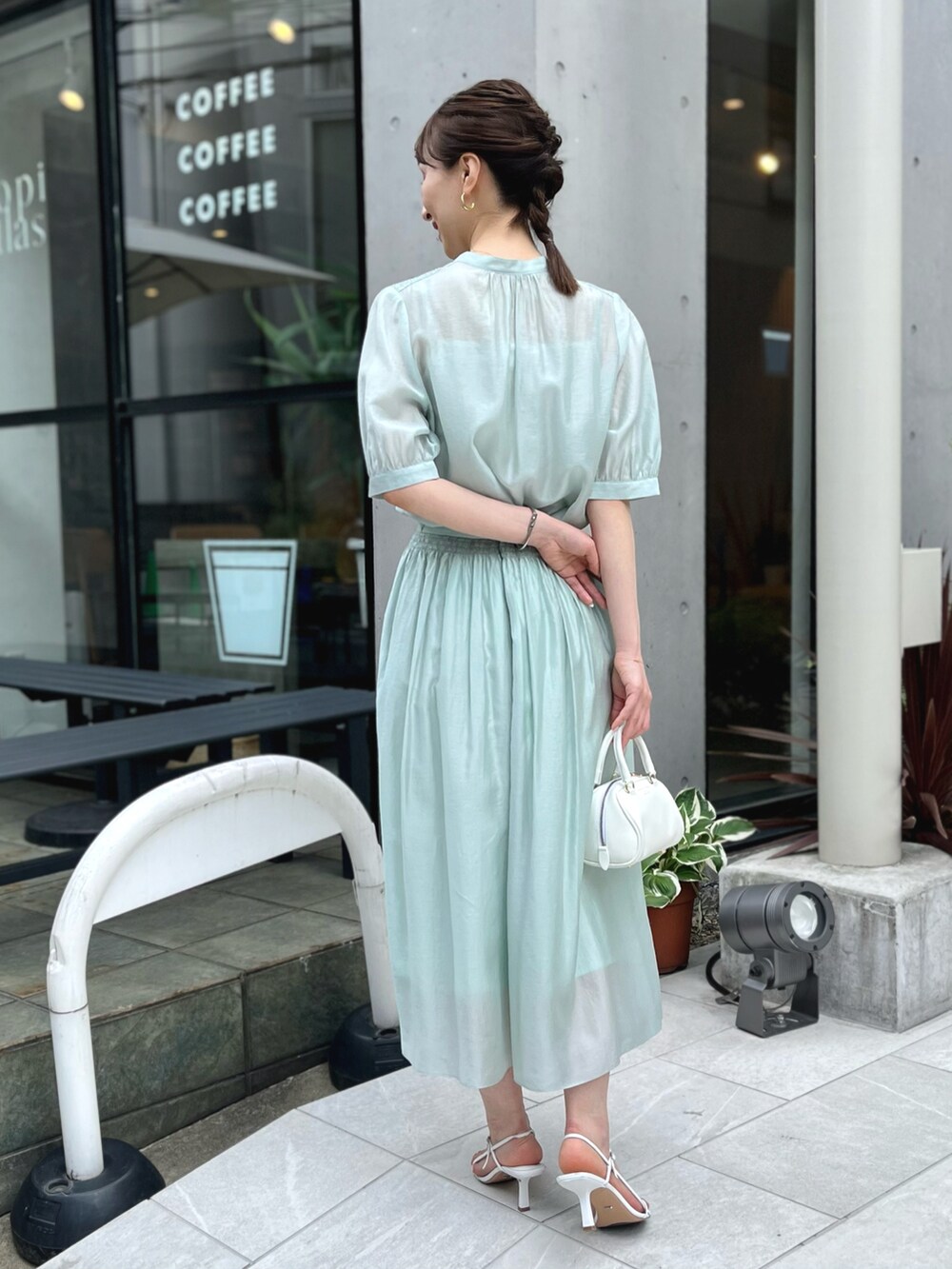 グリーン系のシャツ/ブラウス、グリーン系のスカート、ホワイト系のボストンバッグを着用したレディースの春コーディネートの5枚目の写真