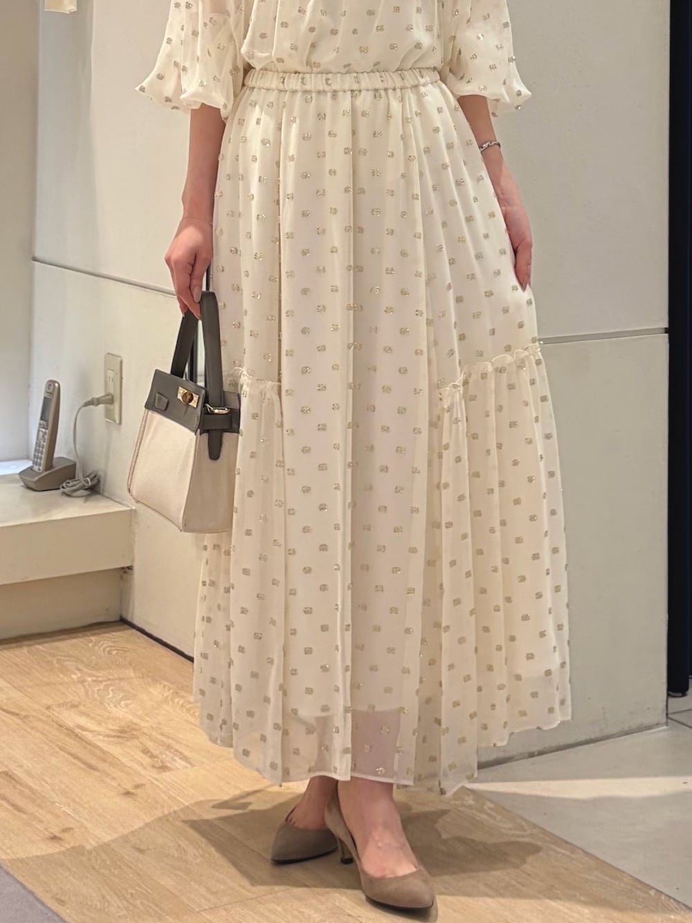 ブラック系のスカート、ホワイト系のシャツ/ブラウス、ホワイト系のキャミソールを着用したレディースの春コーディネートの4枚目の写真