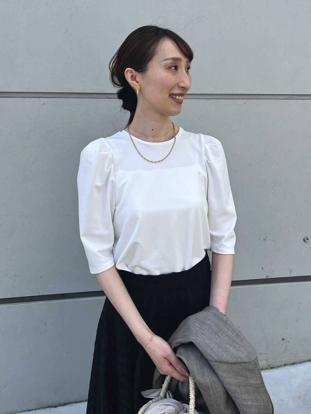 ホワイト系のTシャツ/カットソー、ブラック系のスカート、ブラウン系のテーラードジャケットを着用したレディースの夏コーディネートの2枚目の写真