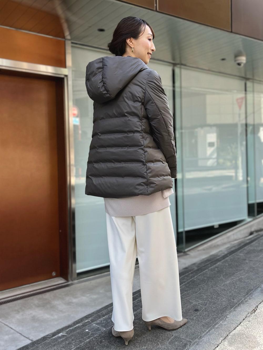 グリーン系のダウンジャケット/コート、ベージュ系のニット/セーター、ホワイト系のその他パンツを着用したレディースの秋コーディネートの5枚目の写真