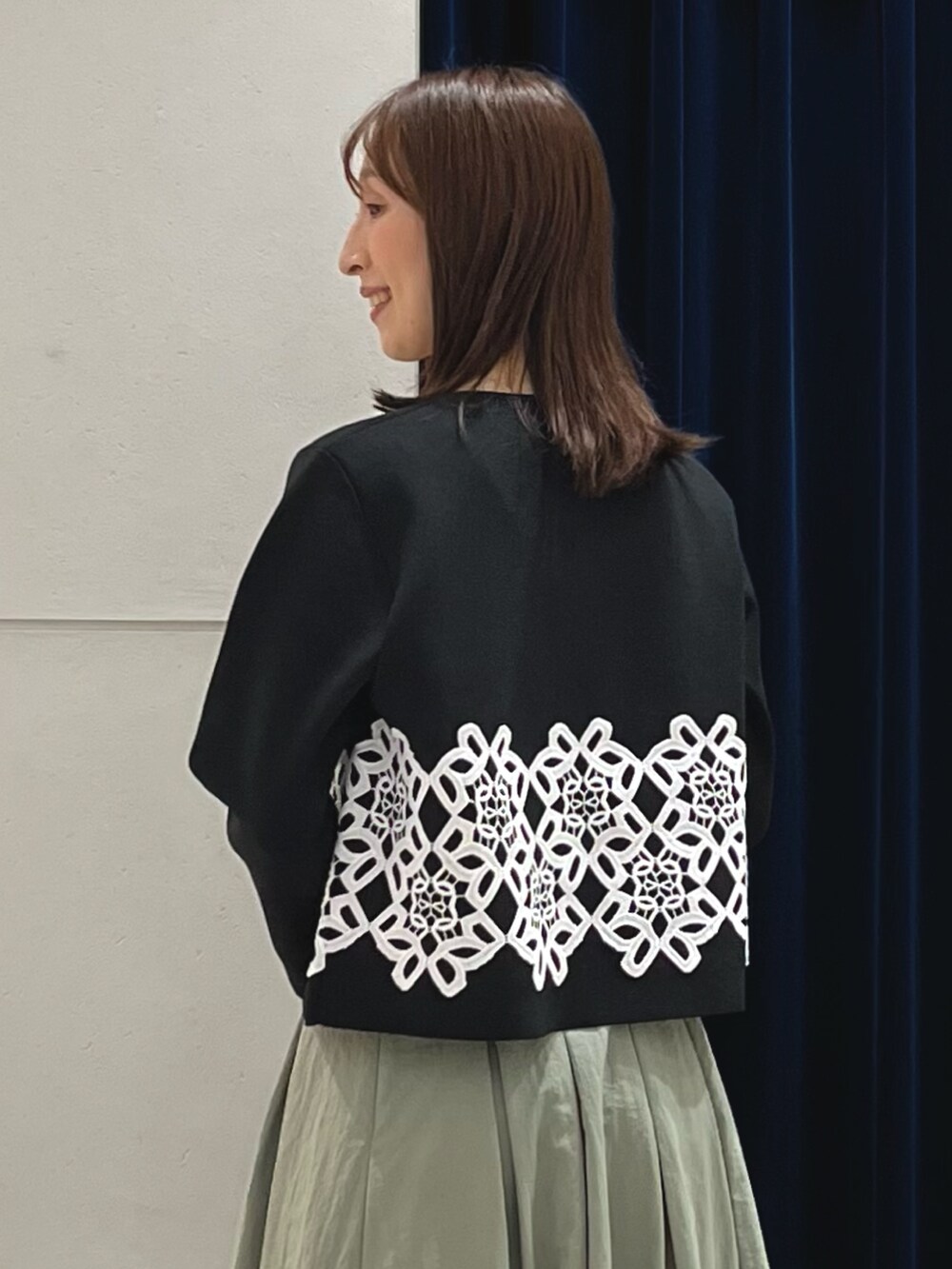 ブラック系のカーディガン/ボレロ、グリーン系のスカート、ブラック系のショルダーバッグを着用したレディースの秋コーディネートの4枚目の写真