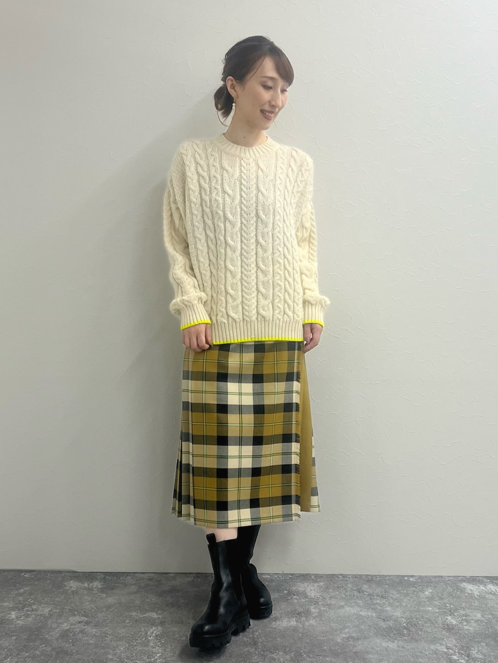 ホワイト系のニット/セーター、ベージュ系のスカート、ブラック系のブーツを着用したレディースの冬コーディネートの3枚目の写真