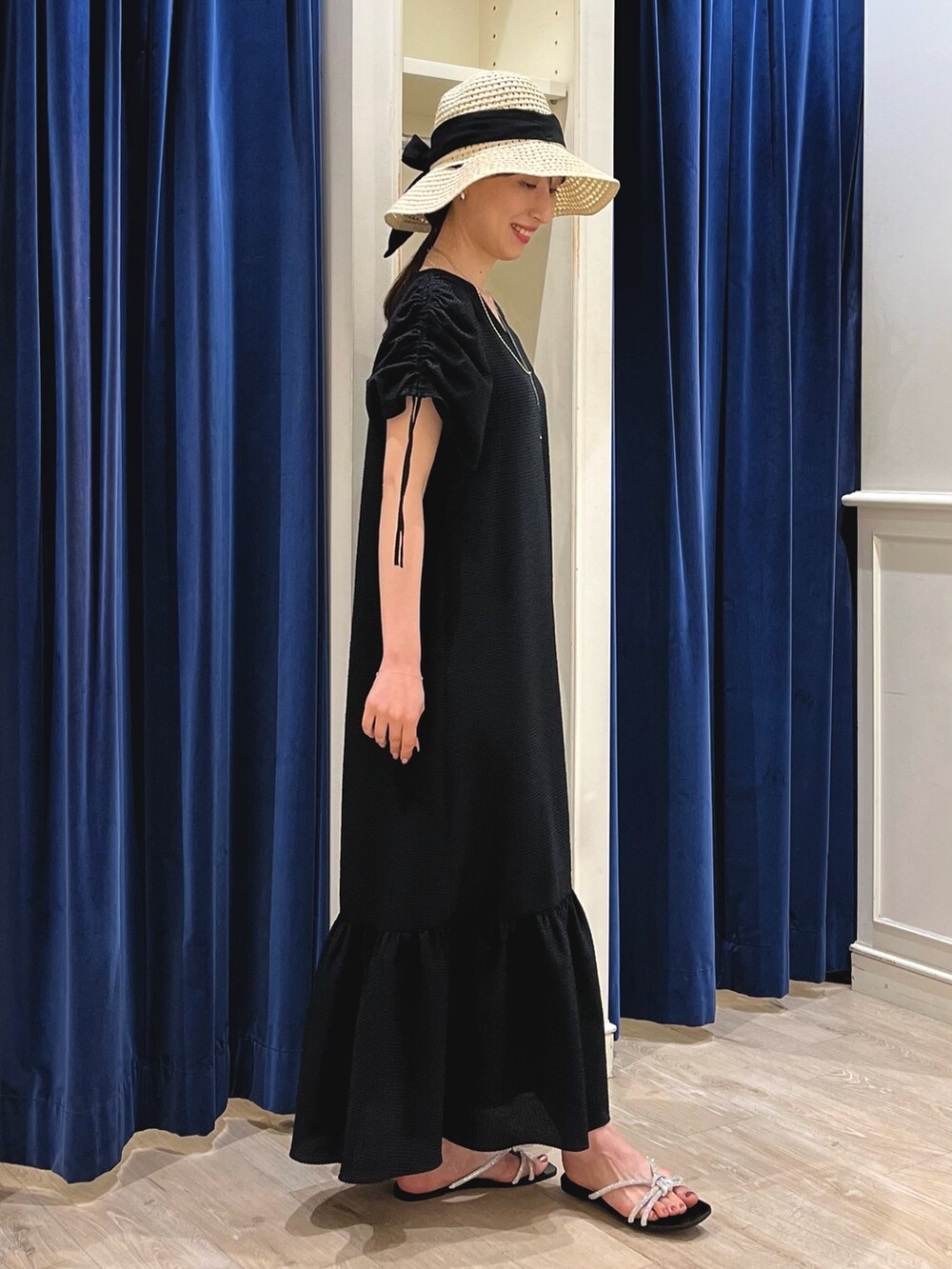 シルバー系のサンダル、ブラック系のワンピース、ベージュ系のハットを着用したレディースの春コーディネートの7枚目の写真