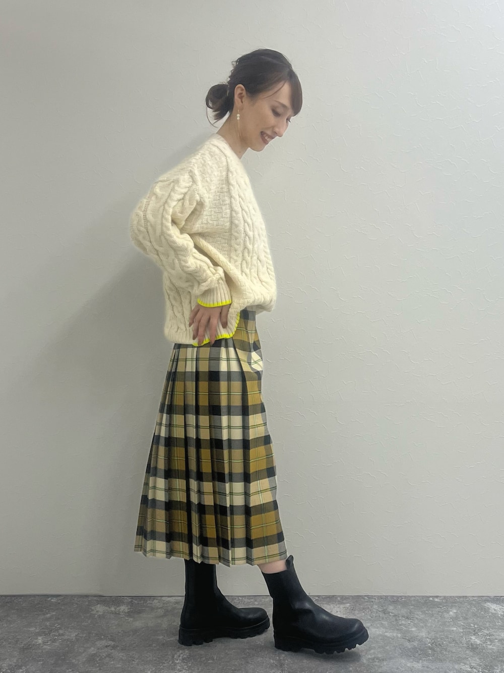 ホワイト系のニット/セーター、ベージュ系のスカート、ブラック系のブーツを着用したレディースの冬コーディネートの4枚目の写真